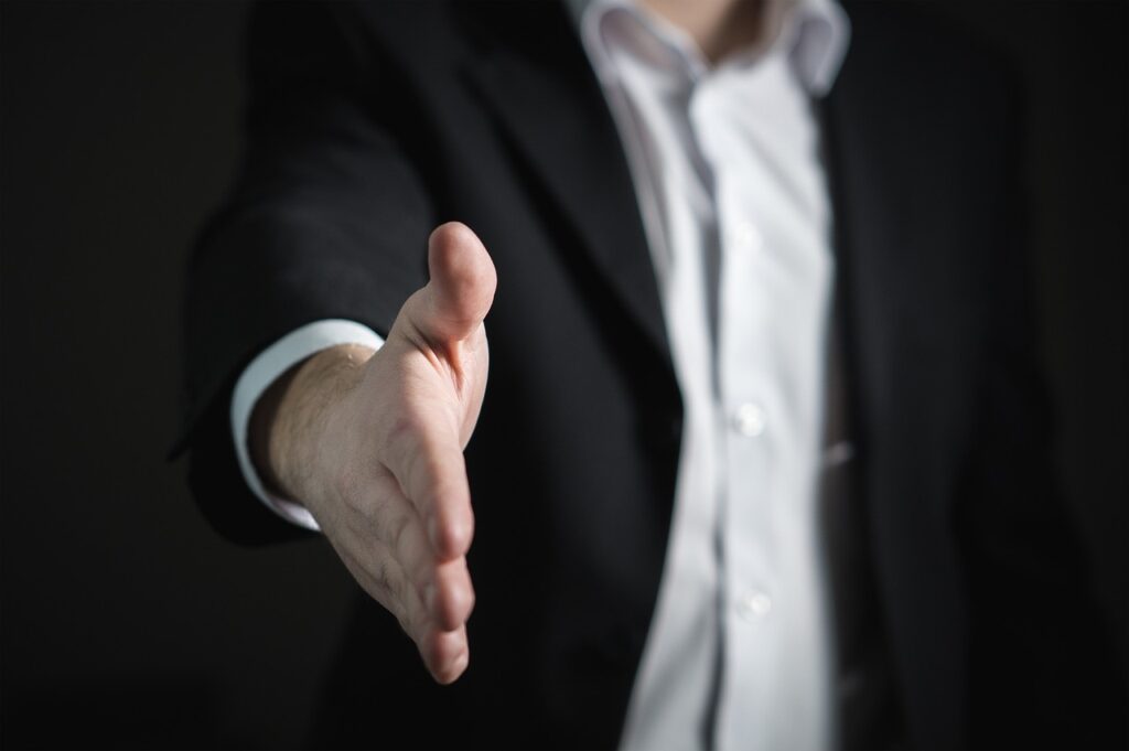 Uomo in abito formale che porge la mano