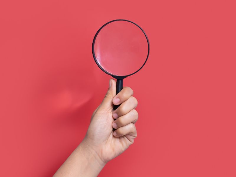 Mano che tiene una lente di ingrandimento
